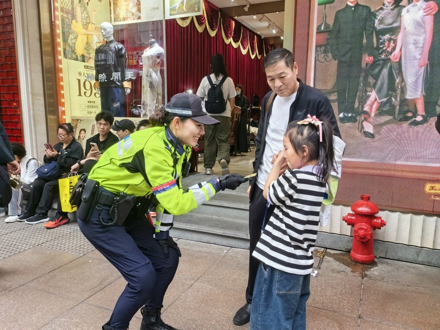徐懿向哭鬧的小朋友遞上棒棒糖。黃浦公安供圖.jpeg