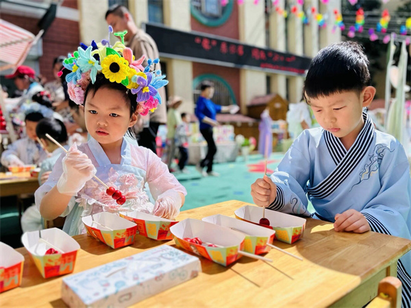 合肥市大西门幼儿园舒馨分园开展“迎'六·一'亲子游园会”孩子们在非遗传承人的带领下感受制作糖葫芦的乐趣