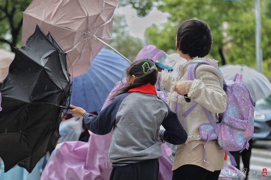 昨天在闵行区平南小学，孩子们顶着风雨上学。记者 赖鑫琳 摄  .jpg