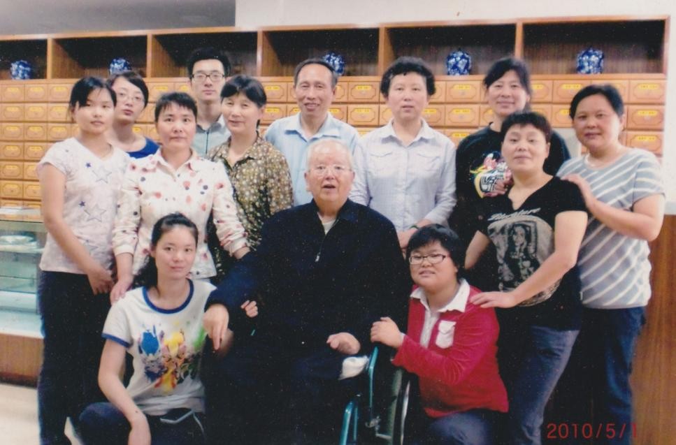 2010年5月1日，徐学春（中间坐轮椅者）与中医诊所职工合影。