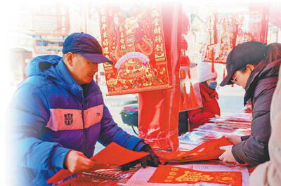 天津楊柳青古鎮(zhèn)御河道年貨大集上，一名顧客在選購年畫。.jpg