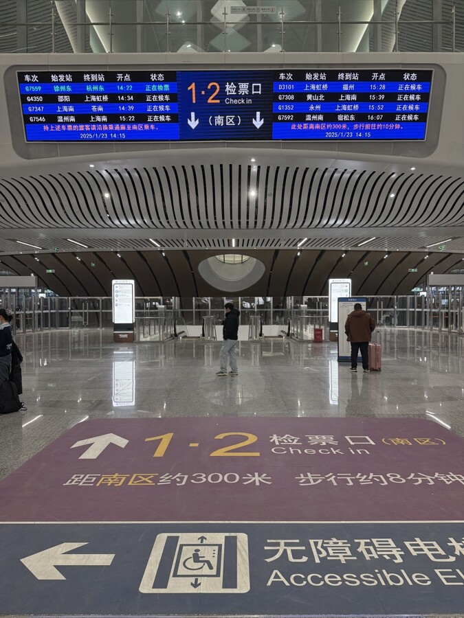 上海松江站北區(qū)檢票大廳上方電子屏幕會(huì)顯示南區(qū)檢票口的位置，地面標(biāo)識(shí)還寫明了距離及步行所需時(shí)間。記者 王一凡 攝.jpg