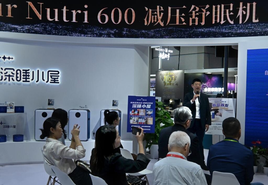 4月13日，在消博會(huì)1號館艾納詩展區(qū)，參展商向人們介紹產(chǎn)品。（王頌 攝）.jpg