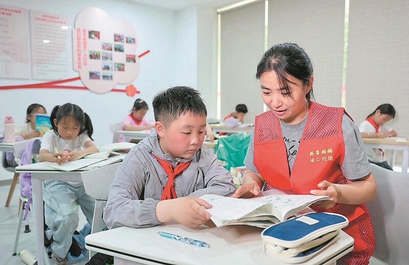 5月7日，“共享媽媽”鮑蕾在包河花園社區(qū)的晚托課堂上給孩子輔導作業(yè)。.jpg