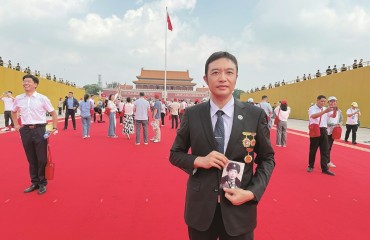 帶著已故父親的軍裝照一起觀禮