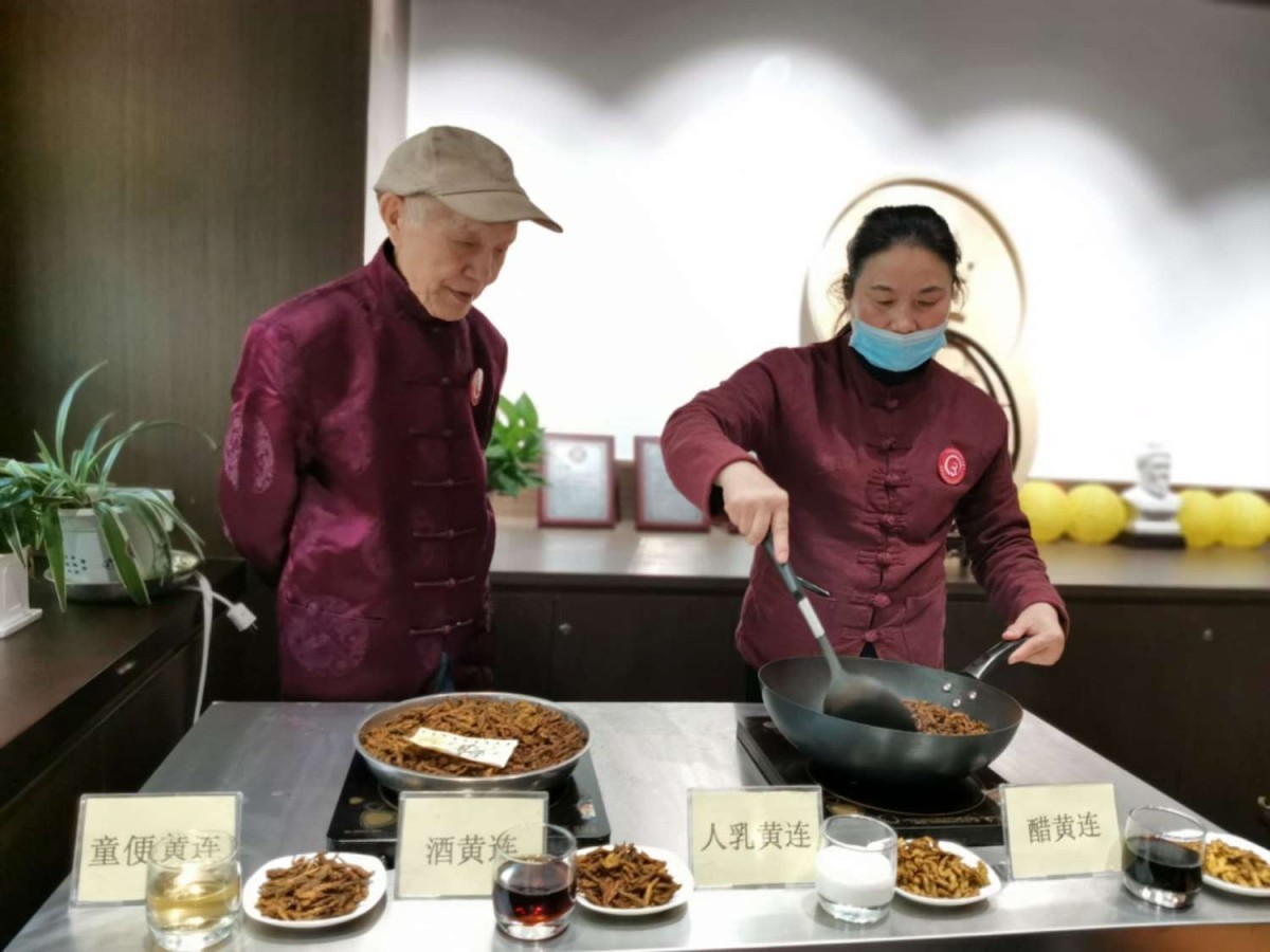 王翠華（右）在對中藥材進(jìn)行炒制，老師楊文琪（左）在旁指導(dǎo)。.jpg