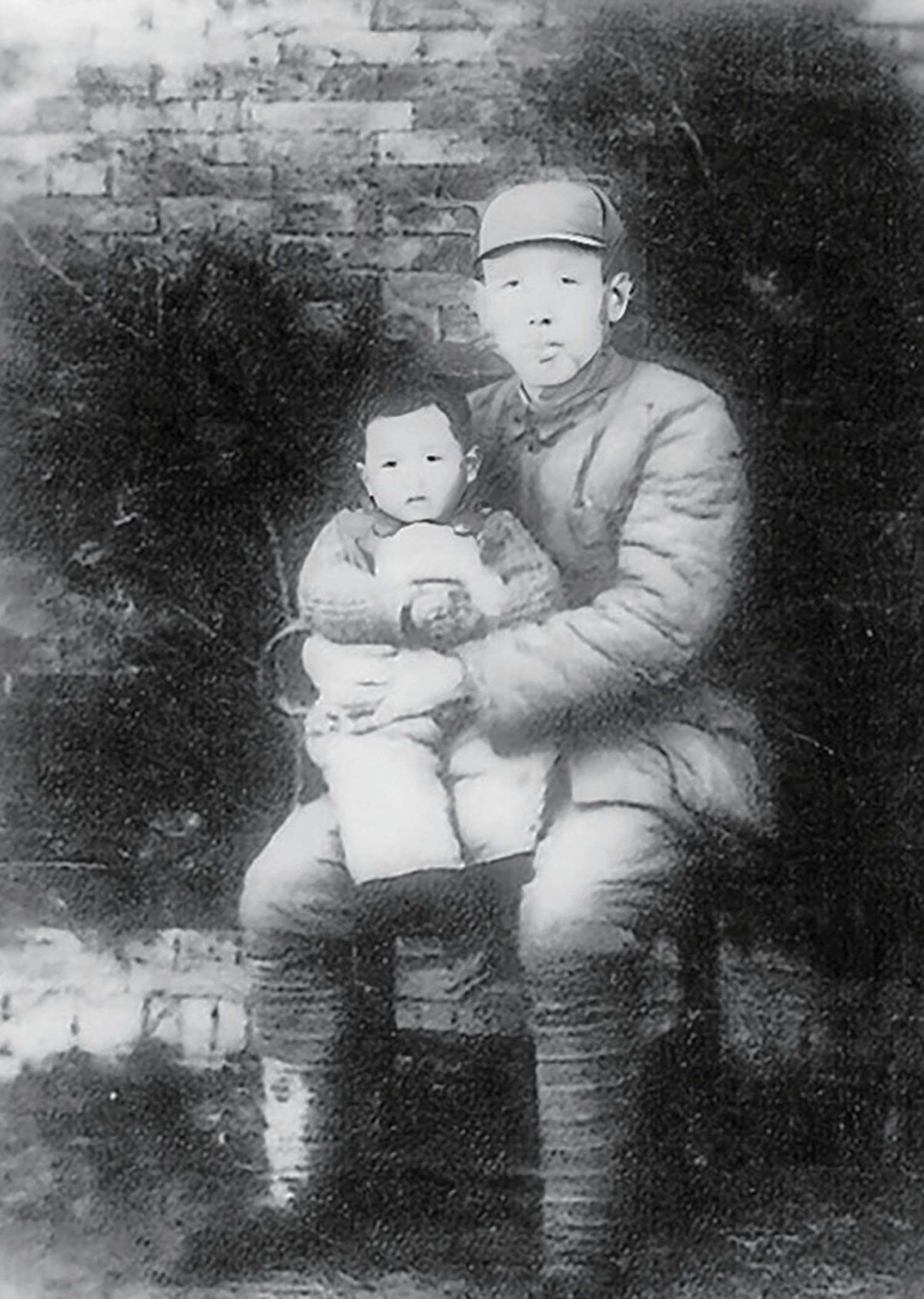 1949 年 3 月，部队出发前，胡文杰怀抱大儿子胡晓军留影.jpg